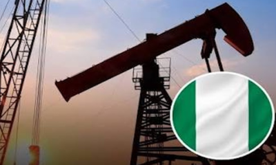 Oil pumpjack silhouetted at sunset with a circular badge showing the Italian flag in the lower-right corner