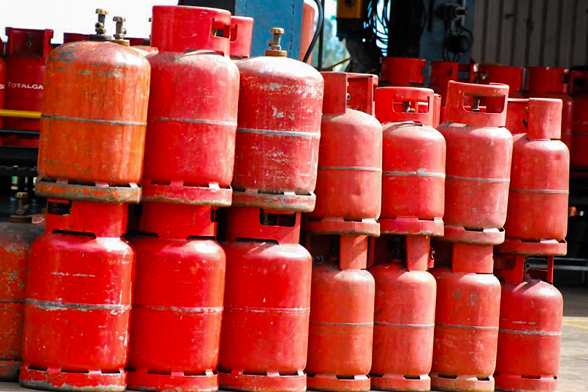 Row of red propane gas cylinders stacked in an outdoor industrial area