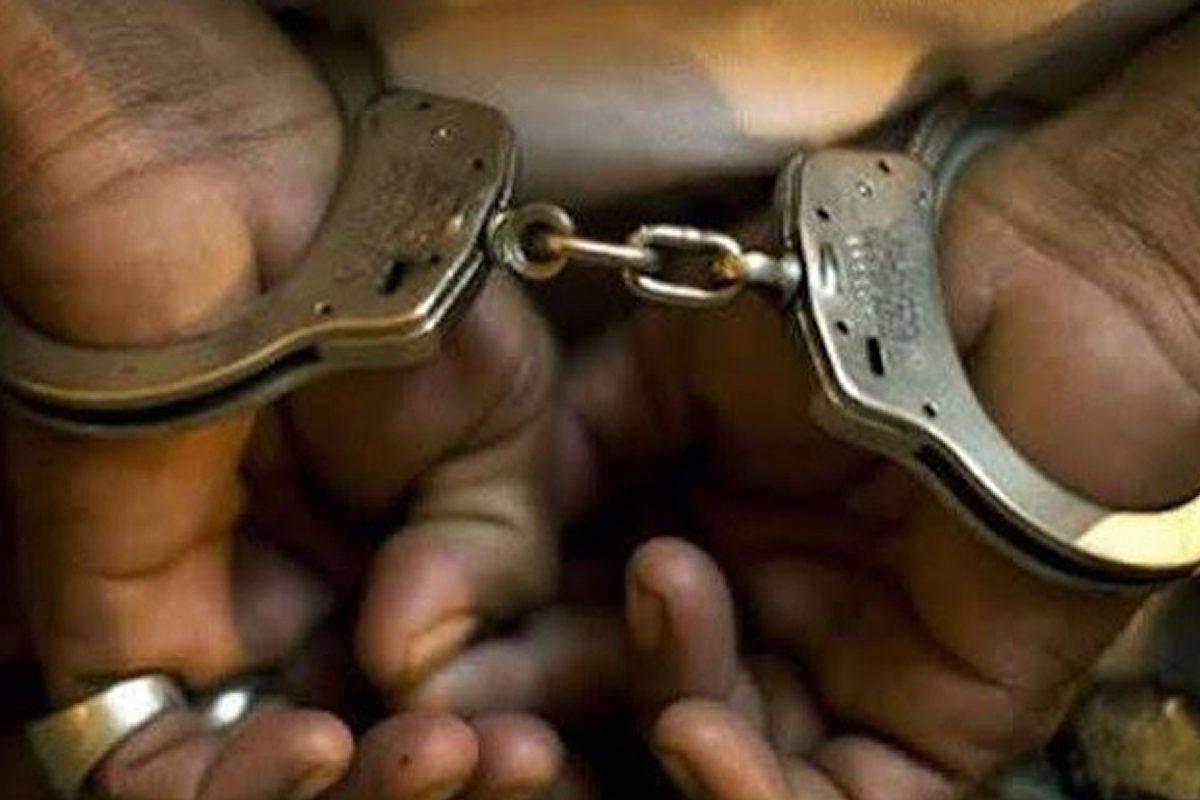 Close-up of hands in metal handcuffs being linked/unlinked, showing chain between cuffs from a close angle, bare fingers visible