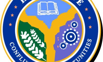 Round seal logo for Kogi State Conference of Opportunities, featuring a blue outer ring and inner map with a book, gears, and plant motifs to symbolize knowledge and industry