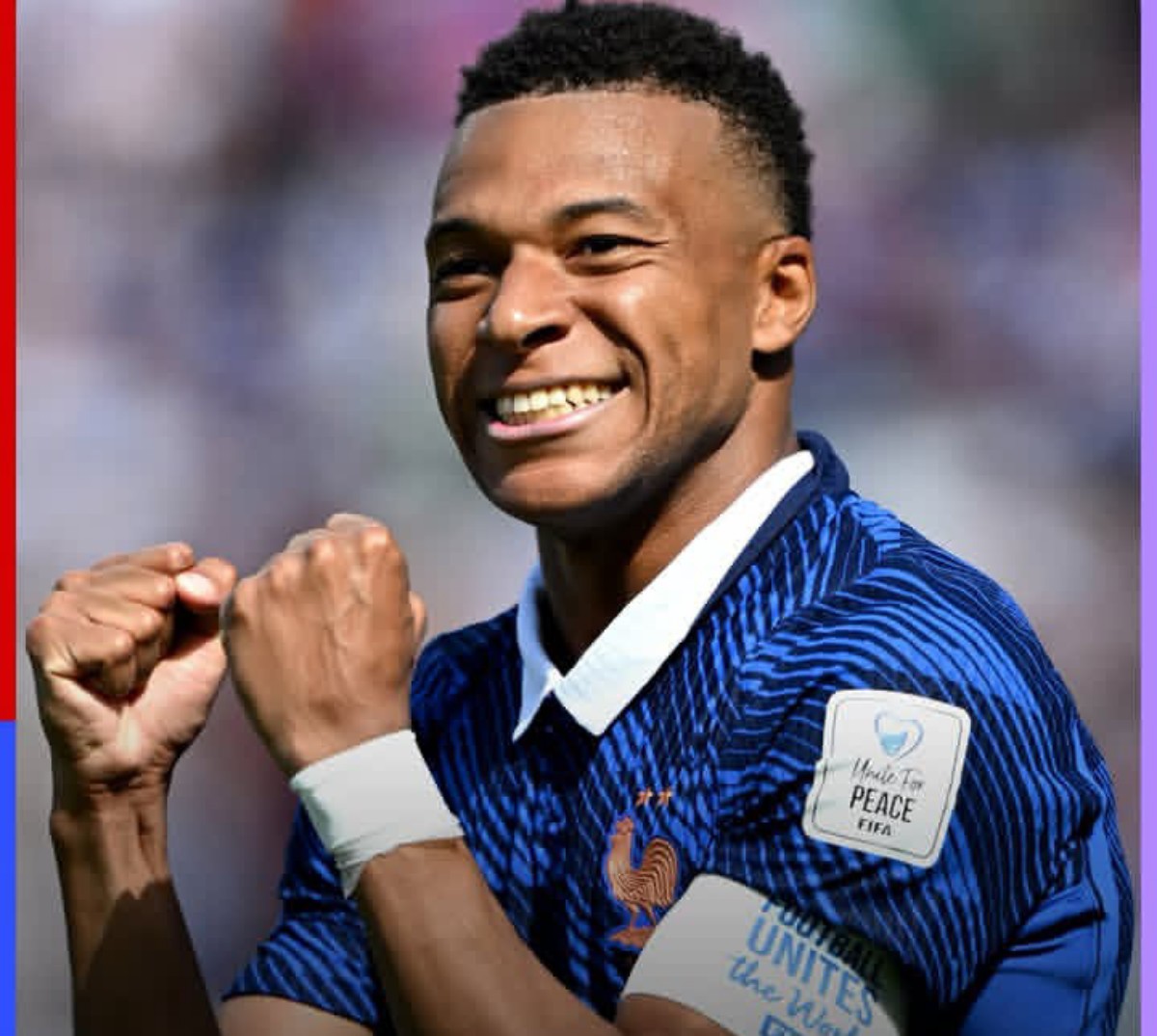 Soccer player in a blue striped jersey celebrating with fists clenched and a smile on his face.