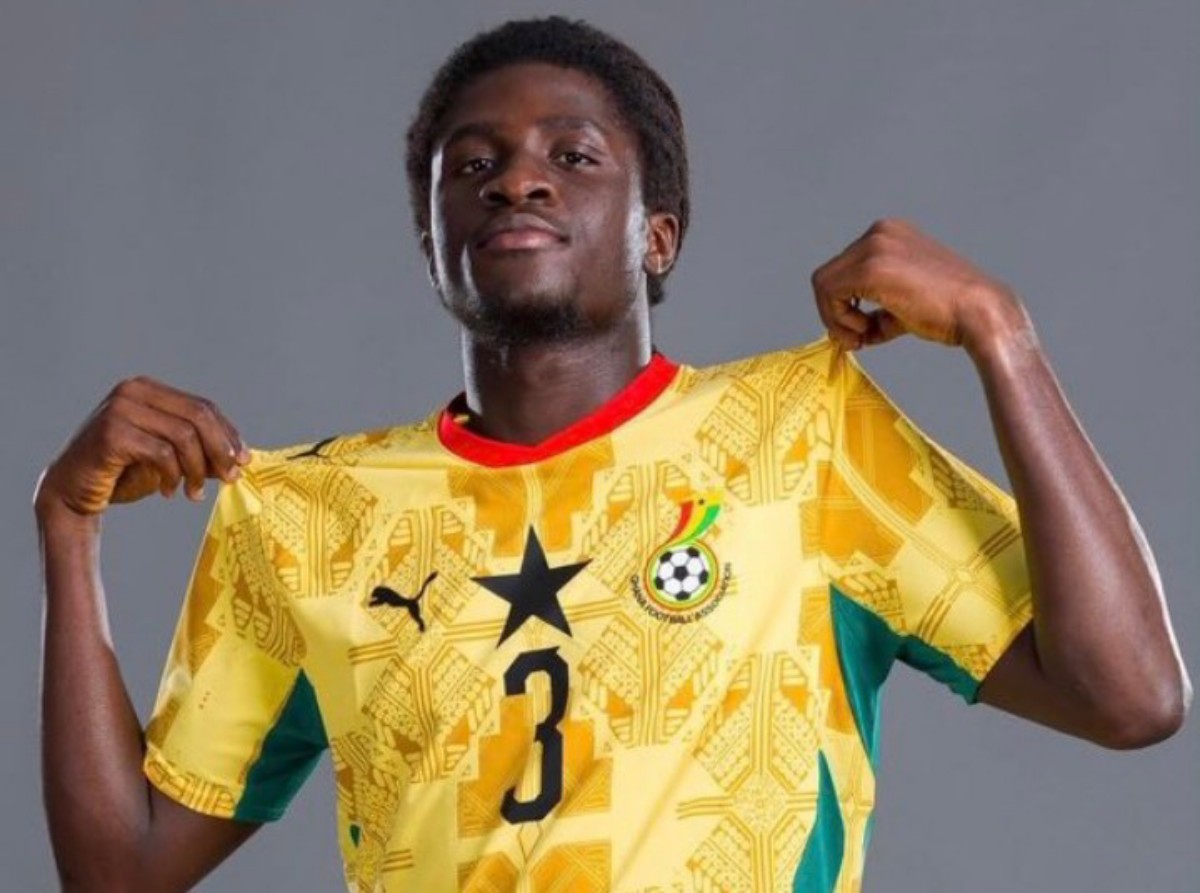 Soccer player wearing a yellow Ghana national team jersey with number 3, lifting the shirt collar in a posing shot.