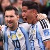 Two Argentine national team players celebrate together, arms around each other, in light-blue and white striped jerseys.