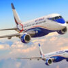 Two Air Peace passenger jets in white and blue livery flying above fluffy clouds in a clear sky.