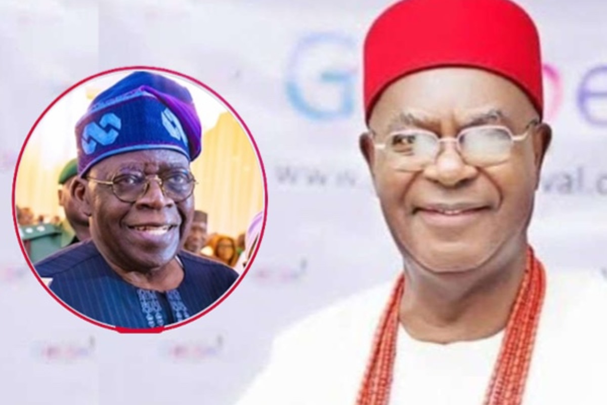 Man in white attire with red cap and beaded necklace smiles at camera; inset shows another smiling man in blue traditional hat.