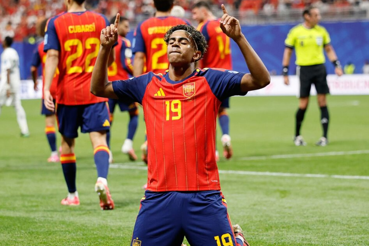 Soccer player in red Spain jersey #19 celebrating on the field with arms raised