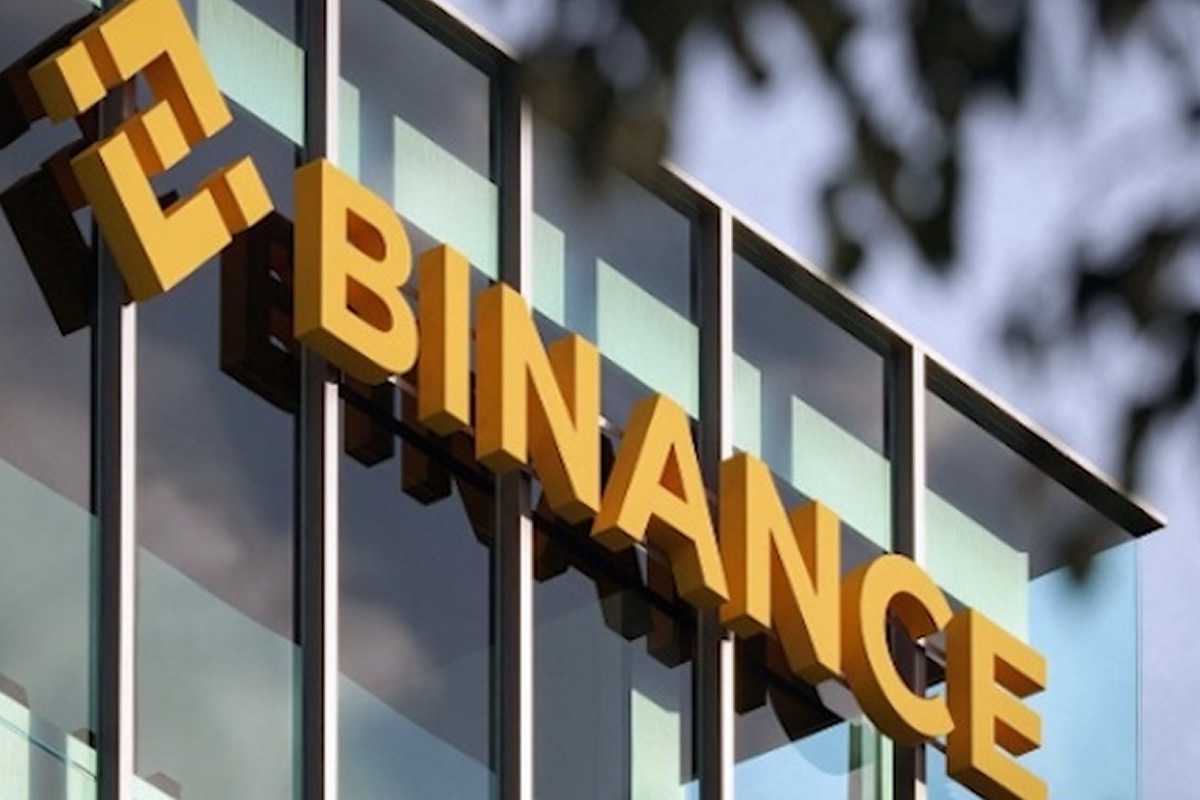 Bold yellow letters spelling FINANCE mounted on a glass-fronted office building.