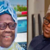 Smiling elderly woman in a blue lace headwrap and glasses (left) and an elderly man in a patterned kufi hat and dark shirt (right).