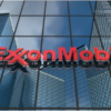 ExxonMobil logo in red on the glass facade of a modern office building.