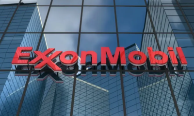 ExxonMobil logo in red on the glass facade of a modern office building.
