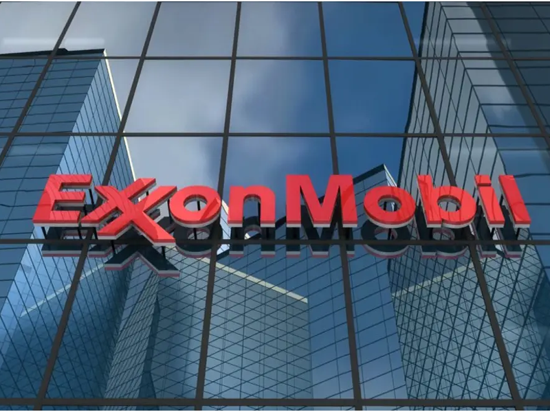 ExxonMobil logo in red on the glass facade of a modern office building.