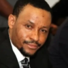Close-up of a man in a suit smiling at the camera.