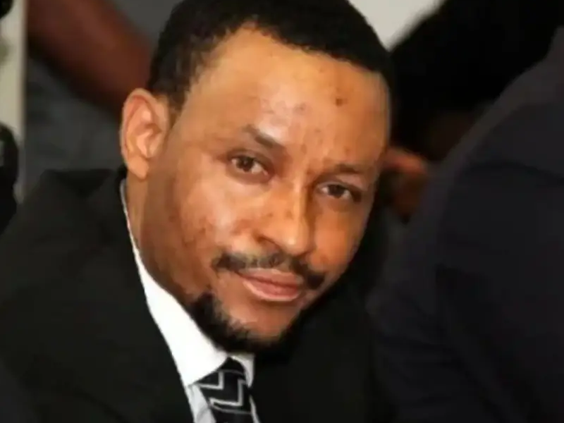 Close-up of a man in a suit smiling at the camera.