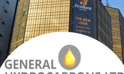 Office building with a FirstBank banner in the background and a foreground General Hydrocarbons Ltd logo featuring a yellow flame within a gray circle.