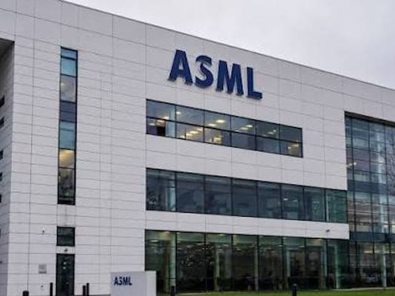 ASML corporate building with a large blue ASML logo on a white facade and glass windows outside.