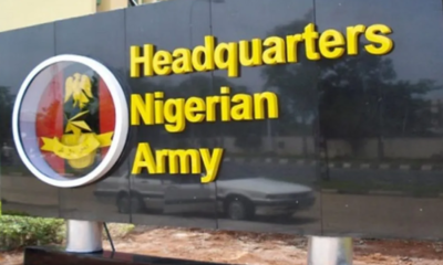 Signboard for the Nigerian Army headquarters, with yellow text on a dark wall and a circular crest emblem