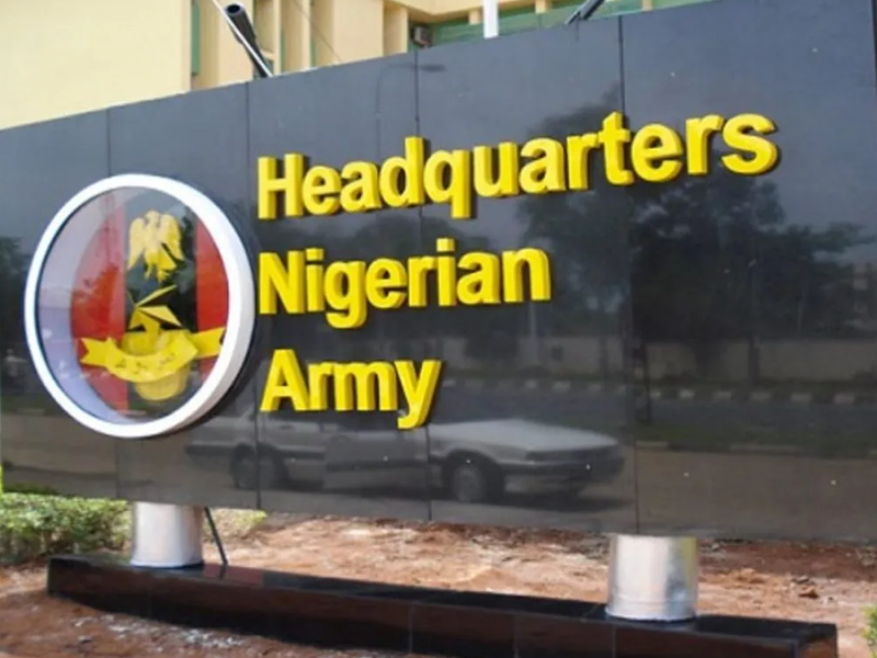 Signboard for the Nigerian Army headquarters, with yellow text on a dark wall and a circular crest emblem