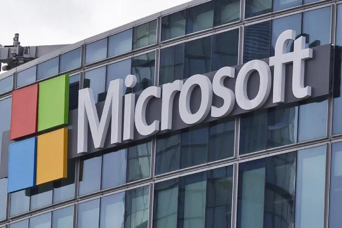 Microsoft logo on a glass-front office building with a red, green, blue, and yellow square icon to the left of the sign.
