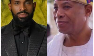 Two men side by side: left, a bearded man in a black textured suit and bow tie; right, a man in white traditional attire with a colorful headwrap, smiling.