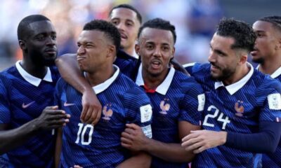 French national team players in blue jerseys celebrate together on the field.