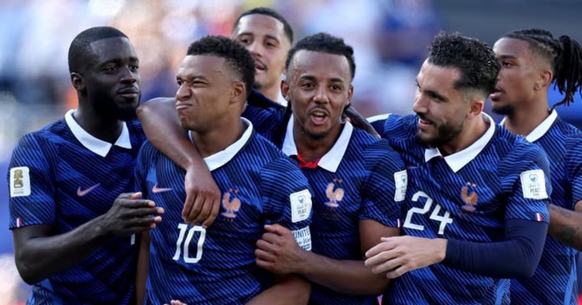 French national team players in blue jerseys celebrate together on the field.