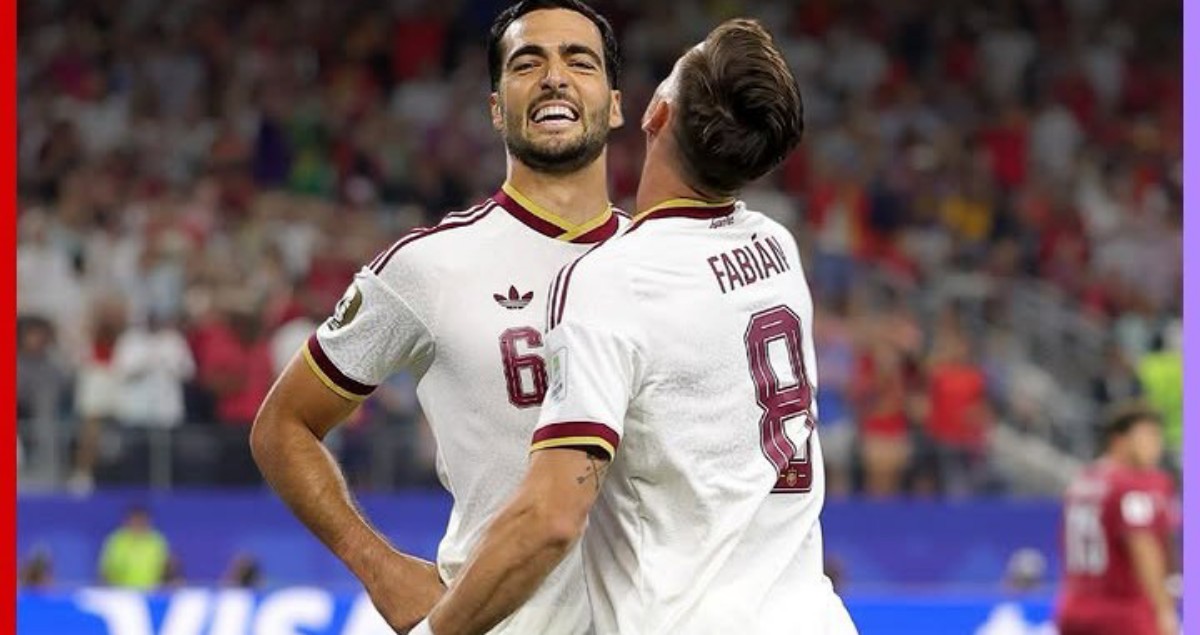 Two male soccer players in white jerseys celebrate on the pitch; numbers 6 and 8 with 'Fabian' on the back.