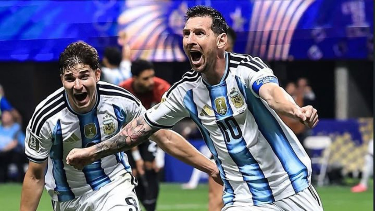 Two Argentina national team football players celebrate on the pitch, arms raised and shouting in blue-and-white striped jerseys with the number 10 visible on one shirt.