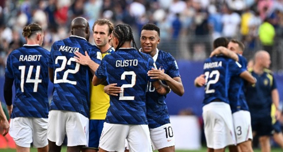 Group of blue-jersey soccer players celebrate on the field, embracing after a game.