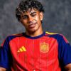 Young man wearing a red Spain national team soccer jersey, smiling against a dark backdrop.