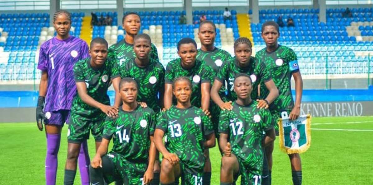 Nigeria women's national football team posing for a group photo on the pitch in green uniforms; goalkeeper in purple on the left.