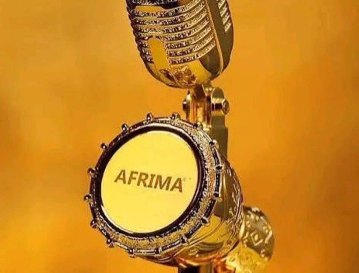 Golden microphone trophy with AFRIMA logo on the mic face against a gold background, close-up.