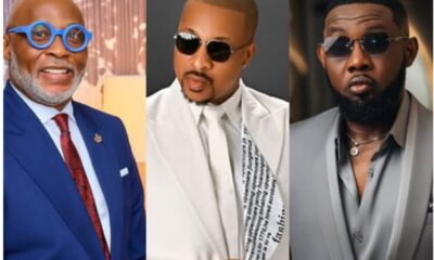 Three men in fashionable suits wearing sunglasses: left in blue suit and bright blue round glasses, smiling; center in white suit with patterned scarf and dark sunglasses; right in gray suit with a beard and aviator-style sunglasses.