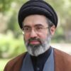 Portrait of a middle-aged man with a black turban, glasses, and gray beard outdoors.
