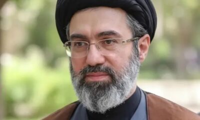 Portrait of a middle-aged man with a black turban, glasses, and gray beard outdoors.