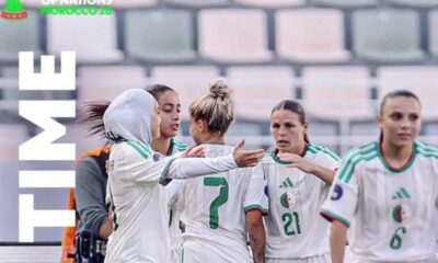 Group of women soccer players in white and green celebrate on the field; a large vertical 'TEAM' text appears on the left.