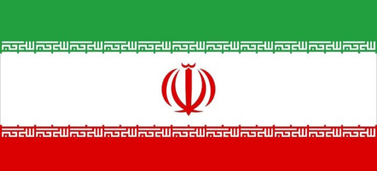 Iranian national flag with green, white, and red horizontal bands, red emblem at center, and Kufic border patterns along the white bands