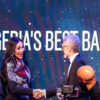 Two professionals shake hands on a stage with a blue backdrop that reads 'NIGERIA'S BEST BANK' and features the Zenith logo.