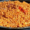 Pan of fried rice with visible orange hues and diced vegetables in a large skillet, ready to serve