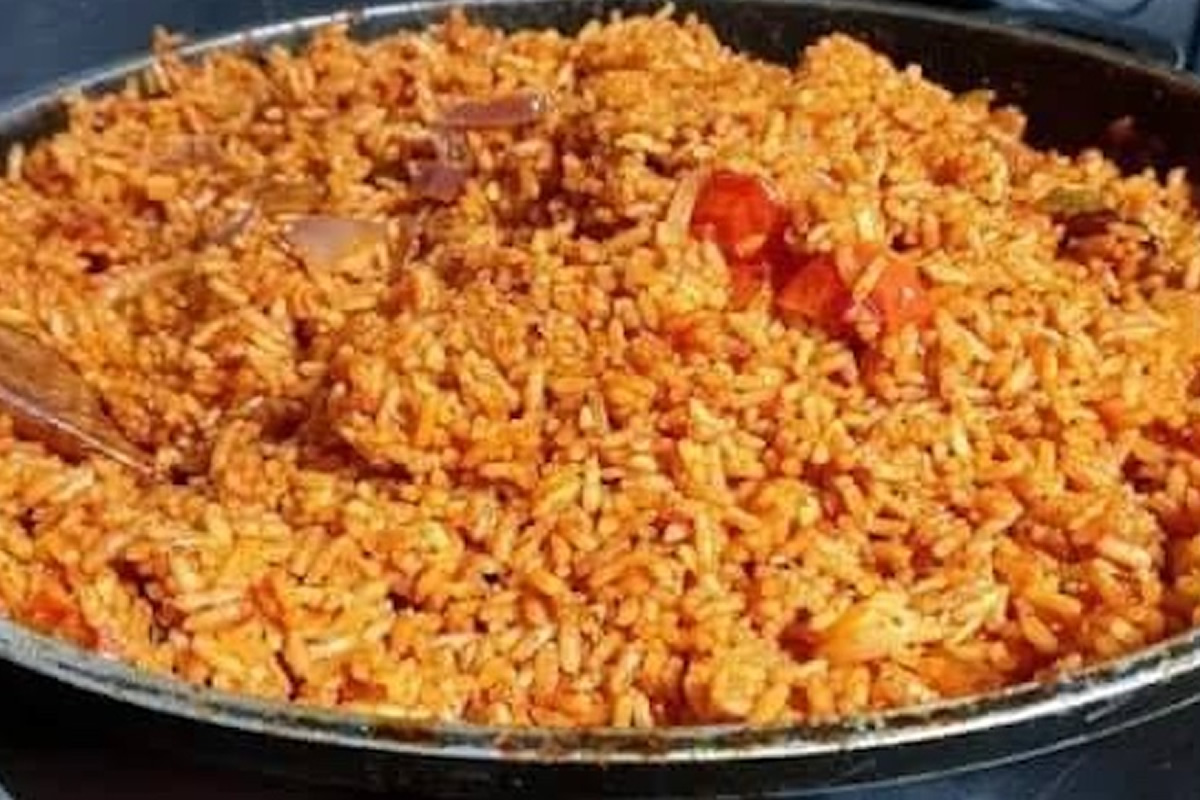 Pan of fried rice with visible orange hues and diced vegetables in a large skillet, ready to serve