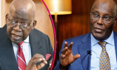 Two suited men in a conversation, left man with red tie and glasses, right man in a blue suit speaking.