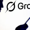Silhouetted person holding a smartphone beside a large Grok logo in the background.