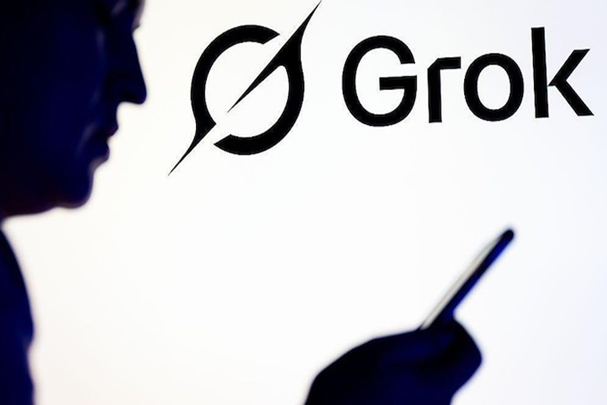Silhouetted person holding a smartphone beside a large Grok logo in the background.