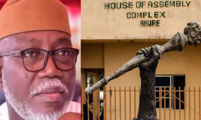Portrait of a man wearing glasses and a brown cap, next to a bronze statue holding a torch in front of the Ondo State House of Assembly Complex, Akure, Nigeria.