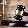 Gavel and scales of justice on a wooden surface, symbolizing law and court decisions