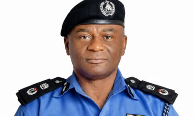 Male police officer in a blue uniform with black epaulettes and a black beret featuring an emblem, facing the camera.
