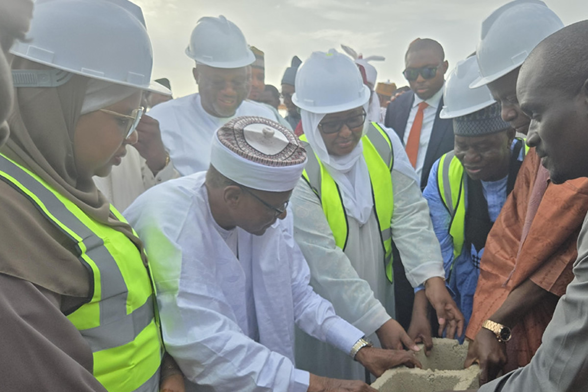 Group of professionals in hard hats and reflective vests building a concrete block together at a construction site