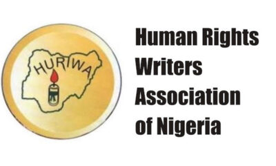 Logo for Human Rights Writers Association of Nigeria, showing Nigeria outline with a candle inside a yellow circle.