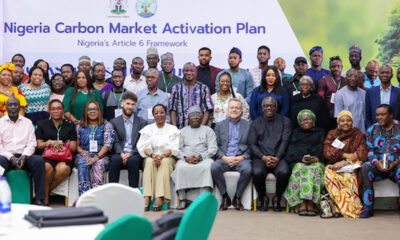 Group photo of diverse attendees at the Nigeria Carbon Market Activation Plan event, banner in the background.