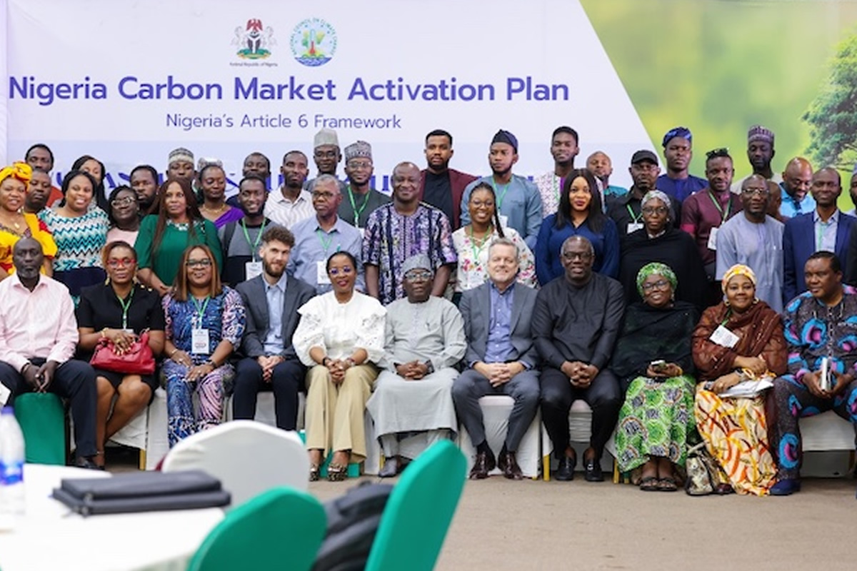 Group photo of diverse attendees at the Nigeria Carbon Market Activation Plan event, banner in the background.