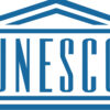 UNESCO logo in blue with a stylized roof motif above and lines framing the word UNESCO
